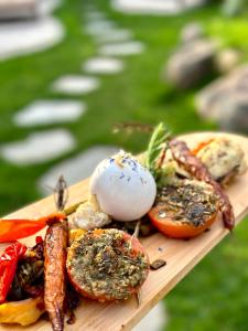 a wooden plate of food with vegetables and sauce at Hôtel Palombaggia in Porto-Vecchio