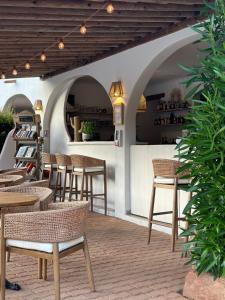 a restaurant with tables and chairs and a bar at Hôtel Palombaggia in Porto-Vecchio