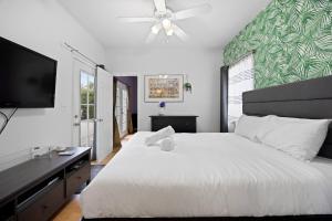 a bedroom with a white bed and a flat screen tv at Cozy Backhouse Stay – Sleeps 2 Beverly Hills Adj in Los Angeles