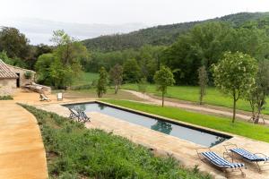 a swimming pool with two chairs and a house at Mas Margot in Llorá