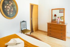 una camera da letto con un letto, uno specchio e una cassettiera di Sea & Soul a Costa da Caparica