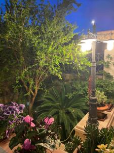 a garden with flowers and a light pole at Casa Manu in Gallipoli