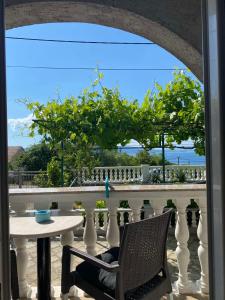 a table and chair on a balcony with a view of the ocean at Room Josip in Senj +8 photos