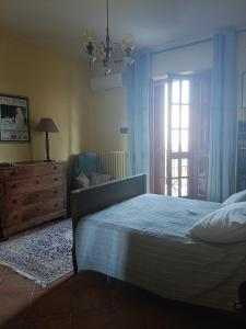 a bedroom with a bed and a dresser and a window at La Ginestra in Cavaglià