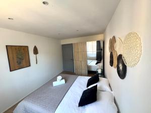 a bedroom with a large white bed with black pillows at Au coeur de Kaysersberg-Le Cocon de Jeanne in Kaysersberg