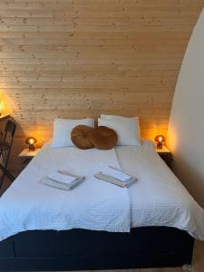 a bed with two towels and two pillows on it at Luxurious Tiny House with HotTub in Rijsenhout