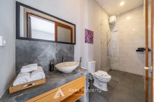 a bathroom with a sink and a toilet at Traditional Villa Astina Cemagi in Cemagi