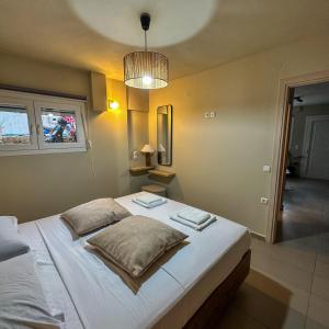 Un dormitorio con una gran cama blanca con dos almohadas. en Dolphin Apartment, en Stalida