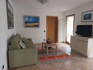 a living room with a couch and a tv at El Tabia De La Maria App Grün In Sospirolo in Sospirolo