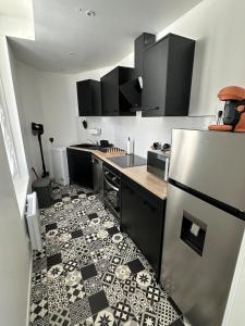 a kitchen with a black and white tile floor at Maison de Village in Châtillon-sur-Indre