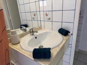 une salle de bain avec un lavabo blanc et un miroir dans l'établissement Appartement 4 personnes à 50 m de la plage, à Narbonne