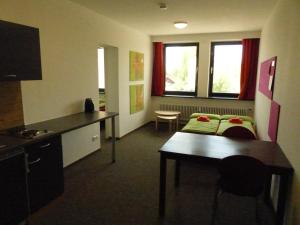 um quarto com uma cozinha e um quarto com uma mesa em Inselhostel em Lindau