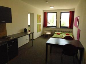 a room with a kitchen and a room with a table at Inselhostel in Lindau