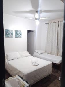 two beds in a room with white walls at Oceano Hotel in Torres +12 photos