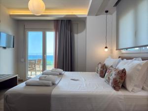 a bedroom with a large bed with a view of the ocean at Elia Beach Villas in Kavála