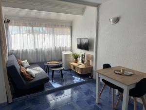 un salon avec un canapé et une table dans l'établissement Appartement 4 personnes à 50 m de la plage, à Narbonne