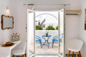 a room with a balcony with a table and chairs at Aegeon Garden in Parikia