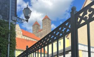 a black fence with a street light and buildings at Hotel Domschatz in Quedlinburg +41 photos