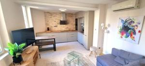 a living room with a blue couch and a kitchen at ! Magnifique Triplex climatisé Avec Sauna Cœur De Ville ! in Metz +15 photos
