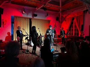 a group of musicians on a stage with a crowd at Le Moulin d'Andé in Andé