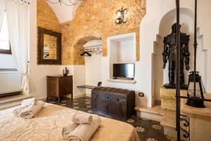 a bedroom with a bed and a tv in a room at Palazzo Gallo Resort in Gallipoli