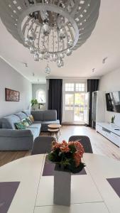 a living room with a couch and a chandelier at Diamond Apartment in Grudziądz
