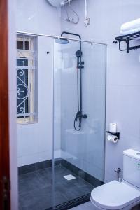 ein Badezimmer mit Glasdusche und Toilette in der Unterkunft The Georges Residence in Kabale + 17 Fotos