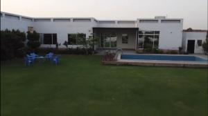 ラホールにあるLux Farm House with Swimming Poolの庭とプール付きの白い家