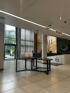 a bench sitting in a room with a table at Menlyn Main Apartments Trilogy in Pretoria +11 photos