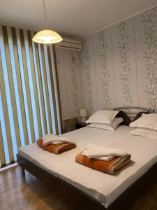 a bedroom with a bed with two towels on it at Belchevi Apartments in Burgas City