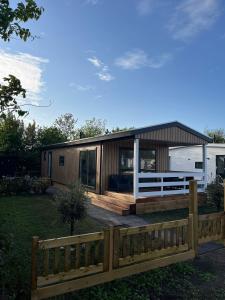 a house with a wooden fence in front of it at Eldorado in Petten