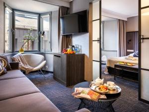 a hotel room with a bed and a living room at Hotel Logos Kraków in Krakow