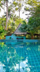 ein Resortpool mit einem Haus im Hintergrund in der Unterkunft Leeloo Paradise in Khanom