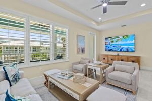 a living room with two chairs and a table at Beach Bound - 2025 Luxury Build - Walk to Beach & Town in Fort Myers Beach