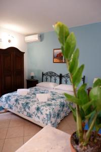 a bedroom with a bed and a potted plant at Sikania Residence in Siracusa