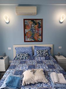 1 dormitorio azul con 1 cama con edredón azul en La Fenice Suite Room, en Finale Ligure