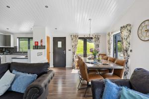 eine Küche und ein Wohnzimmer mit Tisch und Stühlen in der Unterkunft Lilac Lodge, 22 Roadford Lake Lodges in Lifton