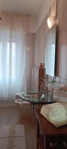 y baño con lavabo de cristal y espejo. en La Fenice Suite Room, en Finale Ligure