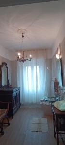 una gran sala de estar con una lámpara de araña y una mesa en La Fenice Suite Room, en Finale Ligure