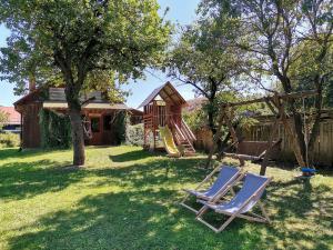 a yard with two lounge chairs and a playground at Agroturystyka Pod Olchami in Lipowiec