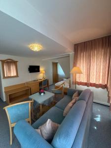 a living room with a blue couch in a room at Hotel Berliner Hof in Braunlage