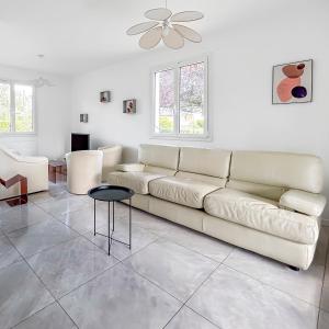 a white living room with a couch and a table at Le Priou - Maison Avec Grand Jardin in Buissou