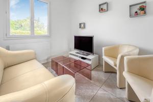 a living room with two chairs and a television at Le Priou - Maison Avec Grand Jardin in Buissou +16 photos