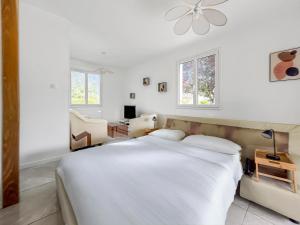 a white bedroom with a bed and a desk at Le Priou - Maison Avec Grand Jardin in Buissou
