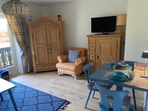 un soggiorno con un tavolo e una TV di Ferienwohnung Christiane - Steilhofweg / Feuerwehrheimstrasse a Bad Reichenhall
