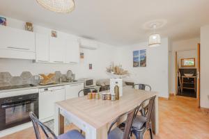 eine Küche und ein Esszimmer mit Tisch und Stühlen in der Unterkunft L'Alivi di Losari 7 - piscine naturelle et jacuzzi in Belgodère