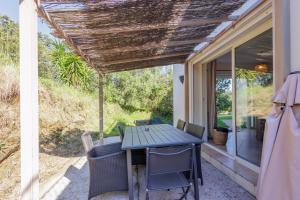 einen Tisch und Stühle auf der Veranda eines Hauses in der Unterkunft L'Alivi di Losari 7 - piscine naturelle et jacuzzi in Belgodère