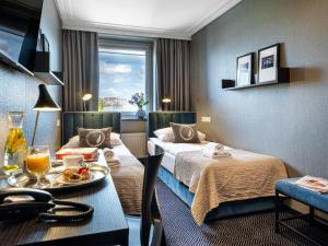 a hotel room with two beds and a table with food on it at Hotel Logos Kraków in Krakow