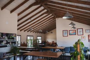 ein Restaurant mit Holzdecken und -tischen sowie Topfpflanzen in der Unterkunft Folk Hostel in El Calafate