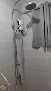 a shower in a bathroom with a shower head at Modern Bahay Kubo in Calaca +26 photos